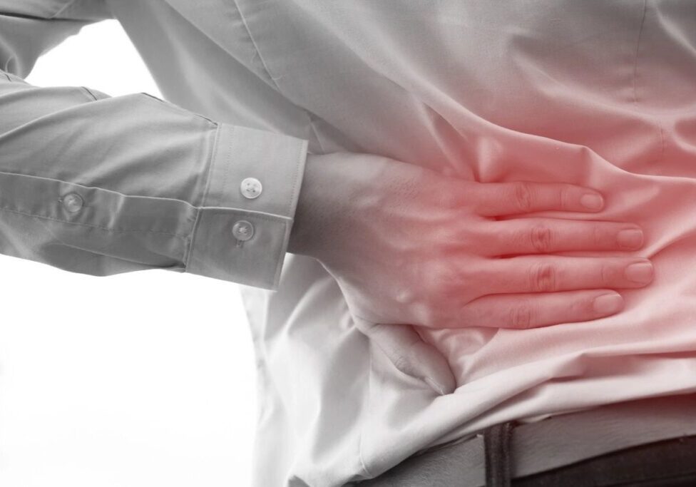 Person holding lower back in pain